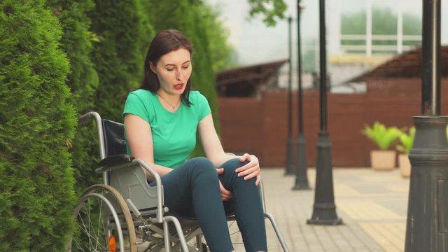 young girl in a wheelchair trying to get up