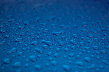 Rain drops on a blue smooth surface.