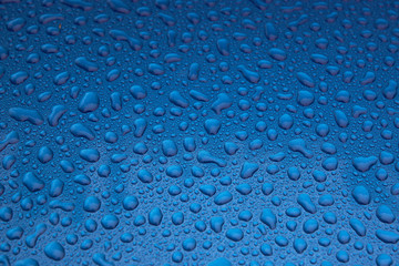 Rain drops on a blue smooth surface.