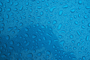 Rain drops on a blue smooth surface.