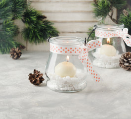glass New Year candle holders with candles on a wooden white table, selective focus