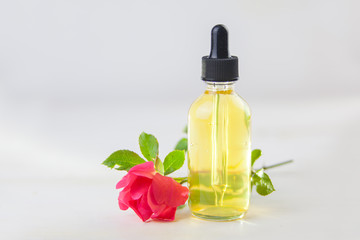 Essence of rose on White background in beautiful glass bottle