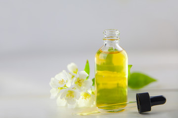 Essence of flowers on white background in beautiful glass jar
