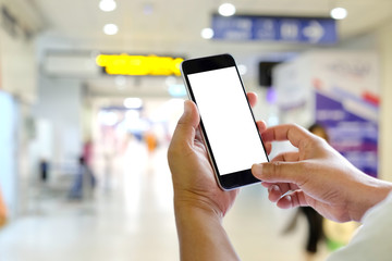 Man using mobile phone in airport terminal.