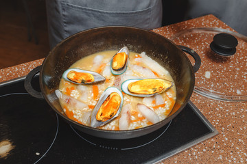 Cooking of a paella in pan in a kitchen