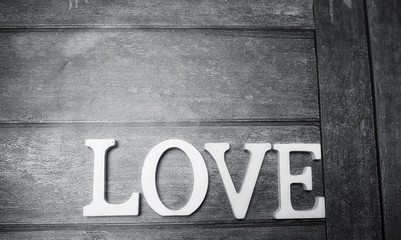 word love made up of white wooden letters on a wooden background