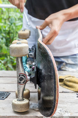 Skateboarder prepares a board for driving in a home workshop
