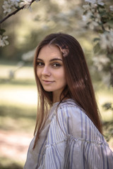 Naklejka premium Pretty young woman in a summer garden, casual romantic style with hat