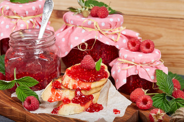 Raspberry jam in jars and toasts with jam. And fresh raspberries.