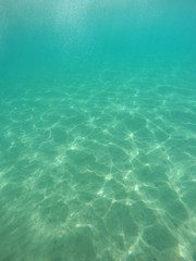 Fondo de la playa bajo agua cristalina