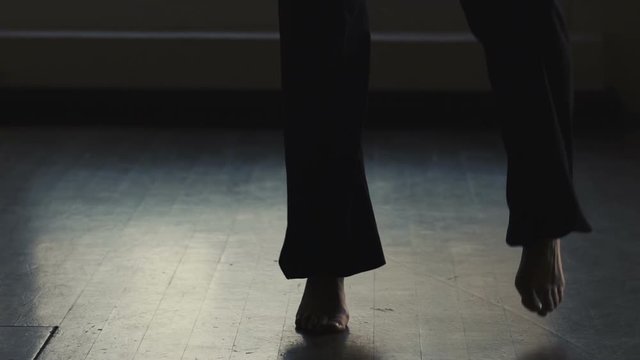 Crop view of women's feet dancing practicing modern dance in the Studio against the window, slow motion