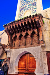 Der Eingang einer Moschee im alten Stil und einem prächtigen hölzernen Tor und Mosaik-Verzierungen in der Stadt Fes in Marokko, Nordafrika © GinaKoch