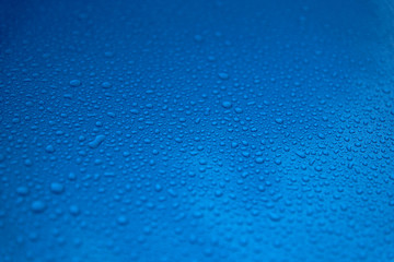 Rain drops on a blue smooth surface.