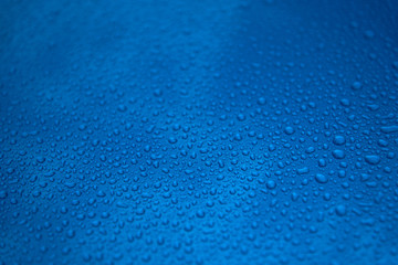 Rain drops on a blue smooth surface.