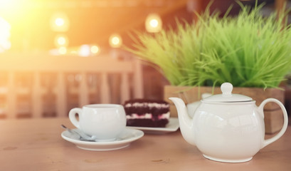 Kettle with a drink and dessert in a street cafe. Tea in the ket