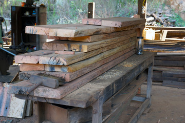 Fototapeta na wymiar madeira cortada ja em forma de pranchas sobre mesa de trabalho em serraria prontas para uso em moveis e outras aplicaçoes sudeste do brasil 2018