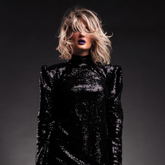 portrait of mysterious and sensual woman in black shiny dress