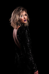 side view of sensual woman with backless black shiny dress