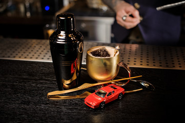 Alcoholic cocktail in the copper cup and bartender equipment