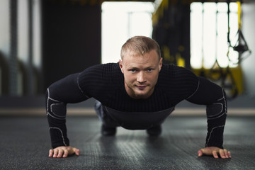 Fototapeta na wymiar Young man fitness workout, push ups or plank