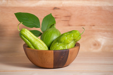 Chayote and melon in wooden bowl on table wood.