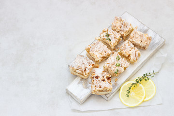 Lemon crumble cake slices or bars on white wooden cutting board, selective focus. Jam bars snack food