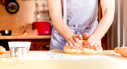 Obraz na płótnie Canvas Female hands making dough on wooden table