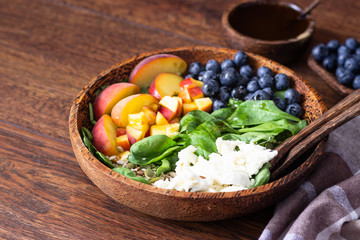 Summer spinach and fruit salad with seeds, mozzarella and balsamic vinegar in a bowl. Summer food concept