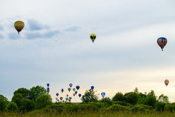 Colorful hot air balloons flying over the field and lake on summ © smspsy