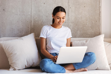 Cheerful young asian woman using laptop computer