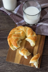 Fresh tasty bread with milk bottle on the wooden table.