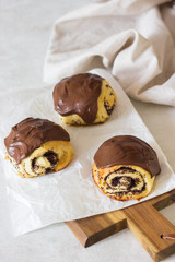 Sweet roll buns with poppy seeds covered with chocolate glaze