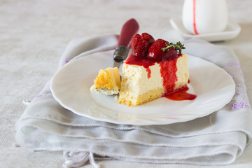 Piece of delicate cheesecake with strawberries sauce on a white plate. 