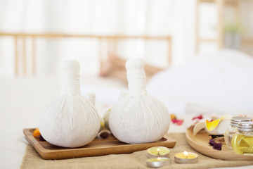 Selective focus Herbal compress balls with oil, on the wooden table in spa salon.  alternative...