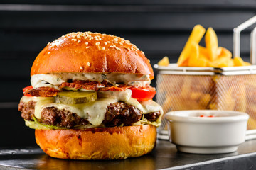 Tasty juicy burger with French fries in the cafe