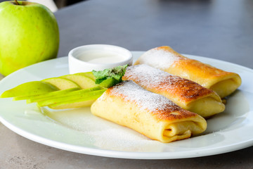Sweet dessert pancakes with apples and powdered sugar o