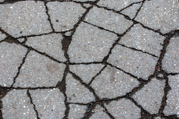 asphalt on the road is covered with cracks
