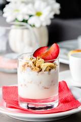 Traditional Italian dessert tiramisu with plum and nuts in a gla