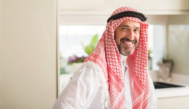 Middle age arabian man at home with a happy face standing and smiling with a confident smile showing teeth
