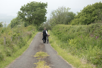 Obraz premium Rear view of a 1940 delivery man on a country road rural setting 