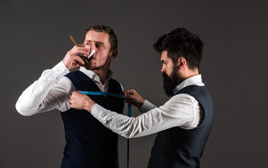 Tailor measure chest for sewing suit, grey background.