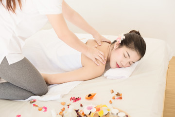 Obraz na płótnie Canvas Young asian woman enjoying relaxing back massage in spa. Body care, skin care, wellness, alternative medicine and relaxation Concept.