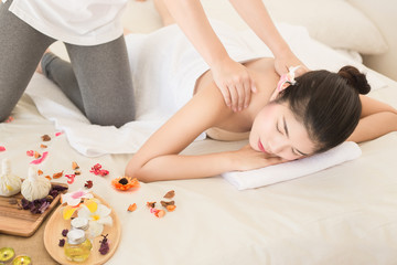 Obraz na płótnie Canvas Young asian woman enjoying relaxing back massage in spa. Body care, skin care, wellness, alternative medicine and relaxation Concept.