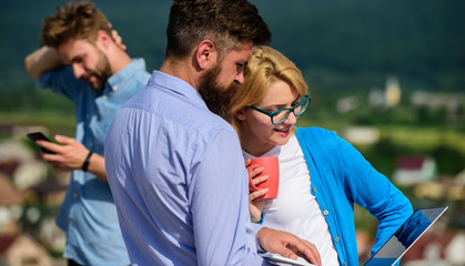 Mobile internet concept. Colleagues business partners with laptop and smartphone taking advantages of mobile internet working outdoor. Colleagues with laptop work outdoor sunny day, nature background