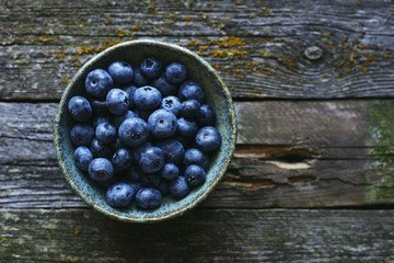 Healthy organic raw blueberries in bowl top view