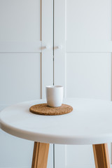 White cup of coffee on the white table