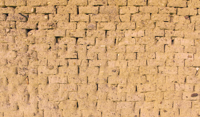 Pared para fondo o textura de ladrillos ( adobe ) de barro y paja  cocido al sol , con piedras...