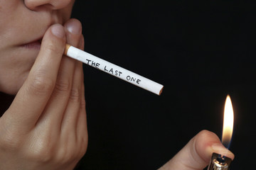 The last one cigarette concept. THE LAST ONE inscription written on a cigarette, stop smoking.