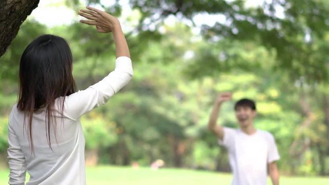 Teenage waving goodbye at outdoors in green park.