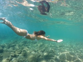 Fototapeta premium Chica buceando en mar de aguas cristalinas